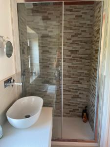 een badkamer met een wastafel en een glazen douche bij La casa dell'ulivo in Imperia