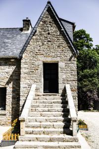 un edificio de piedra con escaleras delante en Le Manoir de Menglieu, en Treffléan