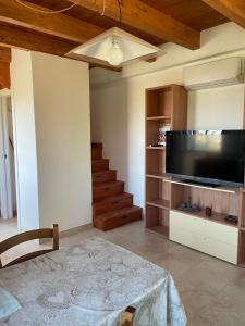 een woonkamer met een flatscreen-tv en een trap bij La casa dell'ulivo in Imperia
