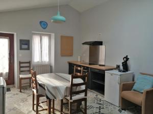 a kitchen with a table and a kitchen with a table and chairs at Lavardac - Maison de Village Gascogne Landes in Lavardac