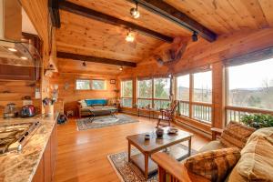 a log cabin living room with a couch and a table at Spacious Finger Lakes Home with Mountain Views 