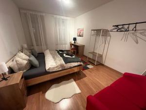 - une chambre avec un lit et un canapé rouge dans l'établissement Ruby-Apartment **Zentrumsnah*Balkon**, à Leipzig