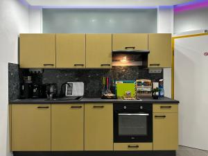 uma cozinha com armários amarelos e um fogão em Modern Apartments Neuburg 1 - TOP NEU - 2 Zimmer, Komfort, Zentrum, Wi-Fi, Smart TV, Stellplatz, Küche em Neuburg an der Donau