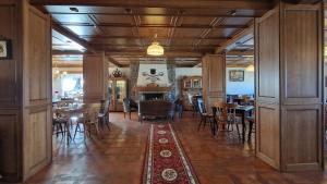 a dining room with tables and chairs and a fireplace at Villa Siana in Bran