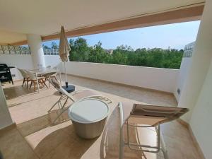 a balcony with a table and chairs on a patio at The Retreat, Valle del Este Modern Apartment in Vera