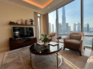 sala de estar con TV, mesa y sillas en Downtown Dubai Address Fountain Views Residences - luxurious One Bedroom Apartment, en Dubái