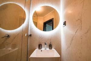 a bathroom with a sink and two circular mirrors at Mustang Boutique Rooms in Oradea +74 photos