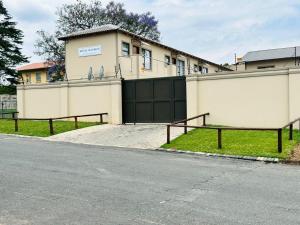 un edificio con una puerta negra y una valla en Royal Mansion Lodge en Johannesburgo