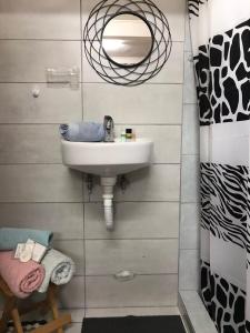 W łazience znajduje się umywalka i lustro. w obiekcie Dimitra's House w mieście Gómfoi