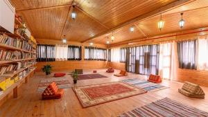 a large living room with wooden ceilings and windows at ערבה גארדן Arava Garden in H̱aẕeva