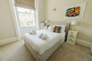 a bedroom with a white bed with towels on it at Luxury, Central, Sun-Filled 3 Bed Haven in Bath in Bath