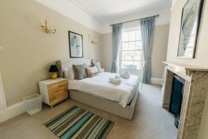 a bedroom with a large bed and a fireplace at Luxury, Central, Sun-Filled 3 Bed Haven in Bath in Bath