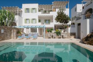 a villa with a swimming pool in front of a building at Anthos Apartments in Naousa