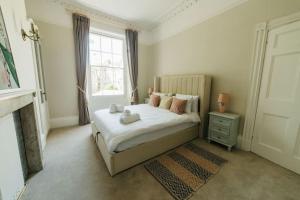 a bedroom with a bed with a fireplace and a window at Luxury, Central, Sun-Filled 3 Bed Haven in Bath in Bath