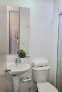 a white bathroom with a toilet and a sink at Amplio y Residencial piso 9 in Cartagena de Indias