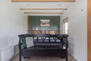 a dark wooden bench in a room with a window at Wildzicht Cosy Cabins in 't Zand