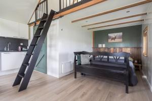 a loft bed in a room with a staircase at Wildzicht Cosy Cabins in 't Zand