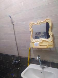 een badkamer met een wastafel en een spiegel aan de muur bij Mooody nobin haws in Abu Simbel