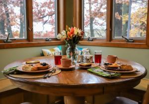 a wooden table with plates of food and flowers on it at LakePlace Bed & Breakfast in Dresser