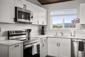 a kitchen with white cabinets and a microwave at The Kabins in Columbia Falls