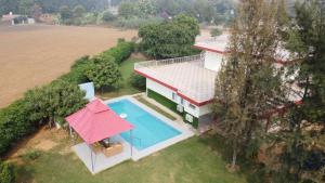 una vista aérea de una casa con piscina en Alaya Stays Luxurious 4BHK Farm with Pvt Pool in Manesar, en Gurgaon