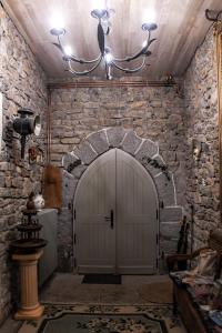 un arco de piedra con una puerta blanca en una habitación en Le Manoir de Menglieu, en Treffléan