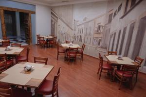 a dining room with tables and chairs and a painting on the wall at Gran Hotel de Querétaro in Querétaro