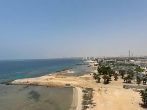 an aerial view of a beach with trees and the ocean at اطلالة الحوراء in Umm Lujj