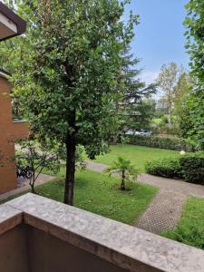 uma vista para um jardim a partir de uma varanda com uma árvore em Casa Vittoria Sirmione Punta Grò con Piscina em Sirmione