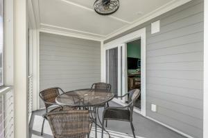 a table and chairs on a porch with a clock at Mariners Cay 68 in Folly Beach