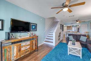 a living room with a couch and a flat screen tv at Mariners Cay 68 in Folly Beach