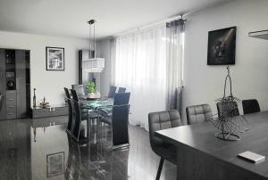 a living room with a dining room table with chairs at Luxury Appartement Marz-Europapark, Rulantika in Mahlberg