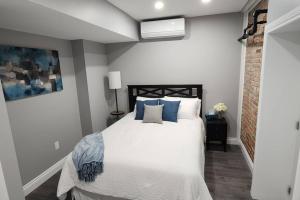 a bedroom with a bed with blue pillows at 12- Exec 1BD-Wifi-AC-Workspace in Windsor