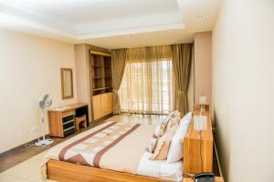 a bedroom with a large bed in front of a window at Rohi Apartments in Kigali