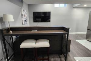 a desk with two stools in a room with a television at 12- Exec 1BD-Wifi-AC-Workspace in Windsor