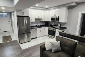 a kitchen with stainless steel appliances and a couch at 12- Exec 1BD-Wifi-AC-Workspace in Windsor