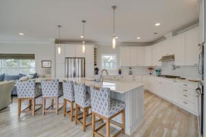 a kitchen with white cabinets and bar stools at Ocean Springs Magnolia Beach House on Pvt Beach! in Ocean Springs