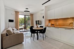 a kitchen and living room with a table and a couch at Apartamenty Belni Hel Edyta i Maciej Wolak in Hel