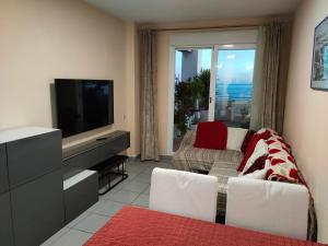 een woonkamer met een tv en een bank bij Piso en la primera linea del mar con 2 dormitorios in Benidorm