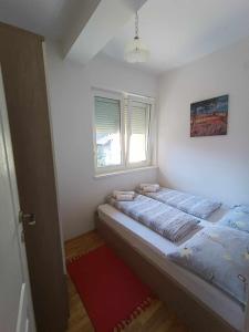 um quarto com 2 camas e uma janela em Apartmani Dar Lux em Banja Koviljača