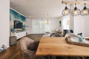 a living room with a wooden table and chairs at Ferienhäuser Baltic Lagoon Haus 14b in Fuhlendorf