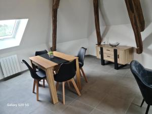 comedor con mesa de madera y sillas en Serrimmo - appartement Bérangère, en Bléneau