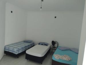 a room with two beds and a table at Casa próxima ao Santuário de Aparecida in Aparecida