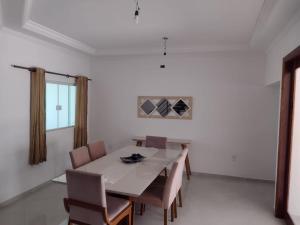 a dining room with a white table and chairs at Casa próxima ao Santuário de Aparecida in Potim +29 photos