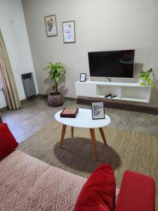a living room with a tv and a coffee table at Real .Departamento in Luján