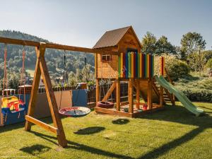 einen Kinderspielplatz mit Holzspielstruktur in der Unterkunft DOMKI NA WCZASOWEJ in Szczyrk