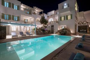 a villa with a swimming pool at night at Anthos Apartments in Naousa