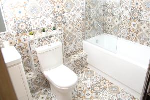 a bathroom with a toilet and a tub and a sink at Manchester Apartments by BEVOLVE - Free Parking in Manchester