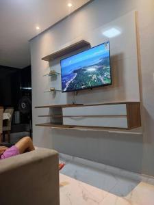 uma televisão de ecrã plano numa parede numa sala de estar em Apartamento Brisa da Ilha em Cairu