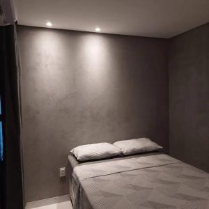 uma cama num quarto com uma parede em Apartamento Brisa da Ilha em Cairu